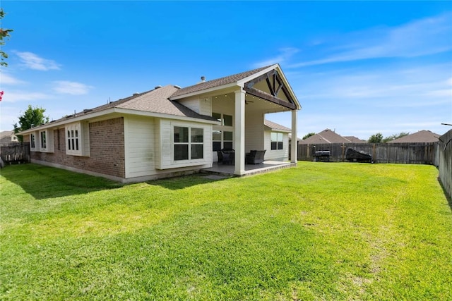 136 W Highfield St, Hutto, TX 78634 - back of property featuring a patio, a fenced backyard, brick siding, and roof with shingles