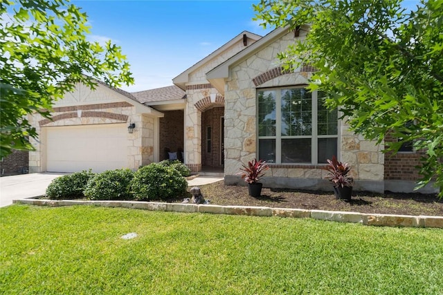 136 W Highfield St, Hutto, TX 78634 - view of front of house featuring stone siding, a garage, a front yard, driveway, and brick siding