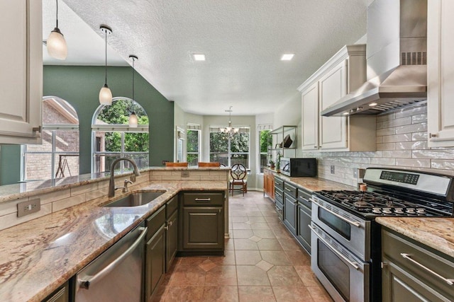 4005 Travis Country Cir, Austin, TX 78735 - kitchen featuring wall chimney exhaust hood, stainless steel appliances, decorative backsplash, light stone counters, and decorative light fixtures