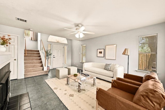 4460 Bremner Dr, Austin, TX 78749 - living area featuring stairs, ceiling fan, dark tile patterned floors, and a fireplace