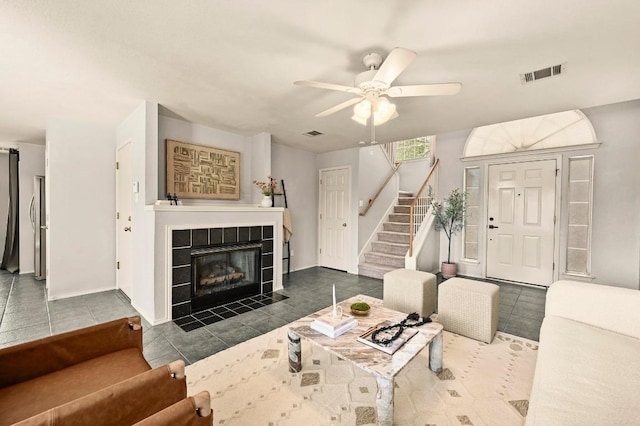 4460 Bremner Dr, Austin, TX 78749 - tiled living room featuring stairway, ceiling fan, and a tile fireplace