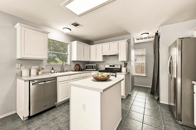 4460 Bremner Dr, Austin, TX 78749 - kitchen featuring stainless steel appliances, white cabinets, and a kitchen island