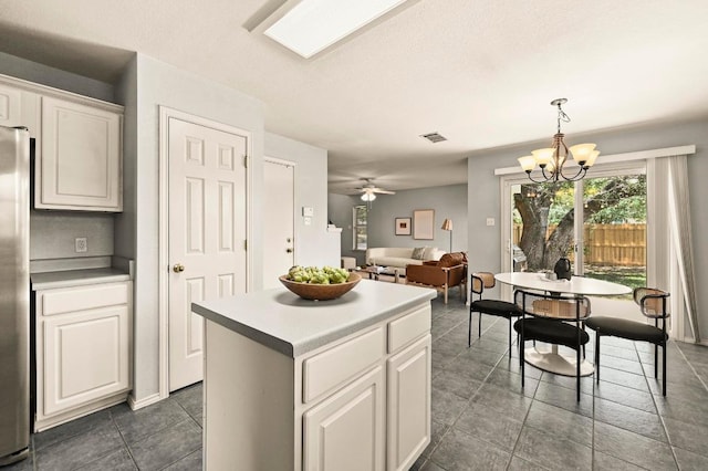 4460 Bremner Dr, Austin, TX 78749 - kitchen featuring a kitchen island, white cabinets, a ceiling fan, and pendant lighting