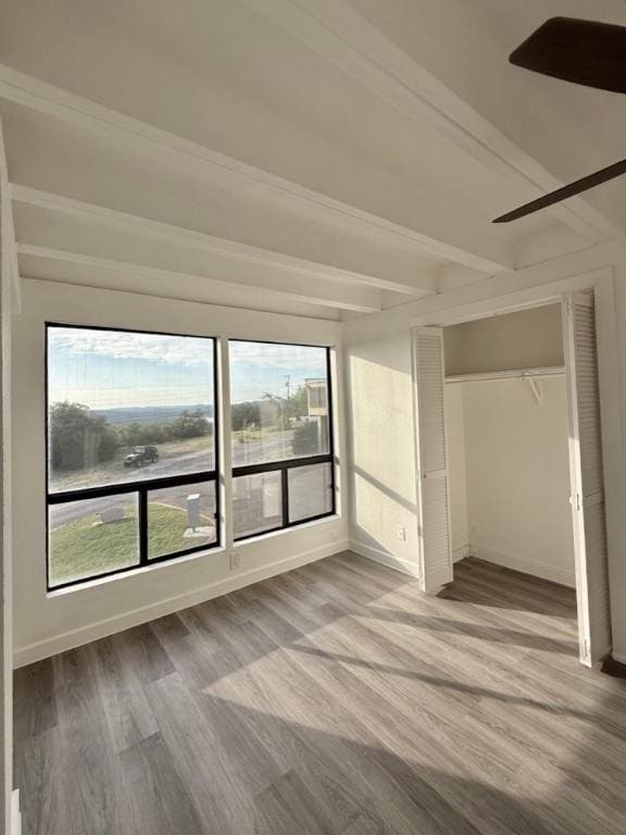 5916 Lago Vista Way Unit B16, Leander, TX 78645 - unfurnished bedroom featuring wood finished floors, multiple windows, beamed ceiling, and a closet