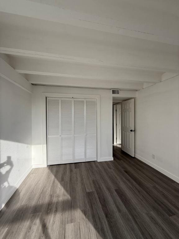 5916 Lago Vista Way Unit B16, Leander, TX 78645 - unfurnished bedroom featuring dark wood finished floors, beam ceiling, and a closet