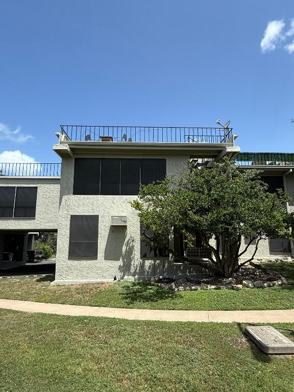 5916 Lago Vista Way Unit B16, Leander, TX 78645 - back of property with stucco siding, a lawn, and a balcony