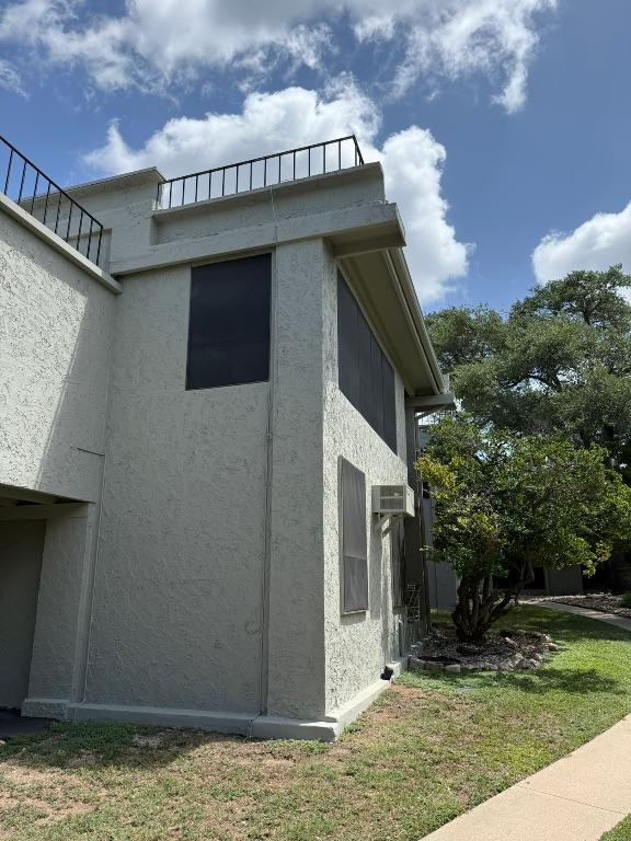 5916 Lago Vista Way Unit B16, Leander, TX 78645 - view of property exterior with stucco siding, a wall mounted air conditioner, and a yard