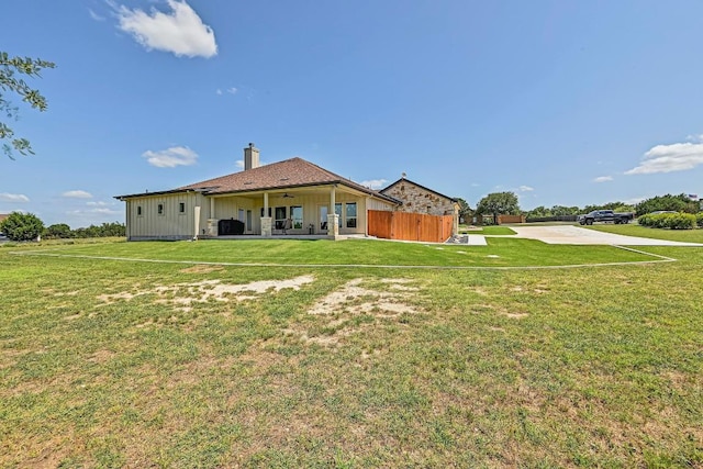 312 First Down Dash, Bertram, TX 78611 - rear view of house with board and batten siding, a yard, and a patio