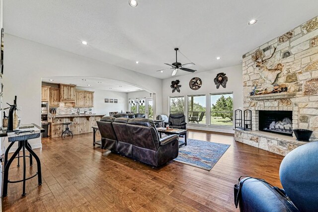 312 First Down Dash, Bertram, TX 78611 - living room featuring arched walkways, dark wood-type flooring, ceiling fan, recessed lighting, and a stone fireplace