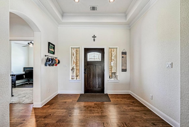 312 First Down Dash, Bertram, TX 78611 - foyer entrance with dark wood finished floors, arched walkways, a raised ceiling, a textured wall, and crown molding