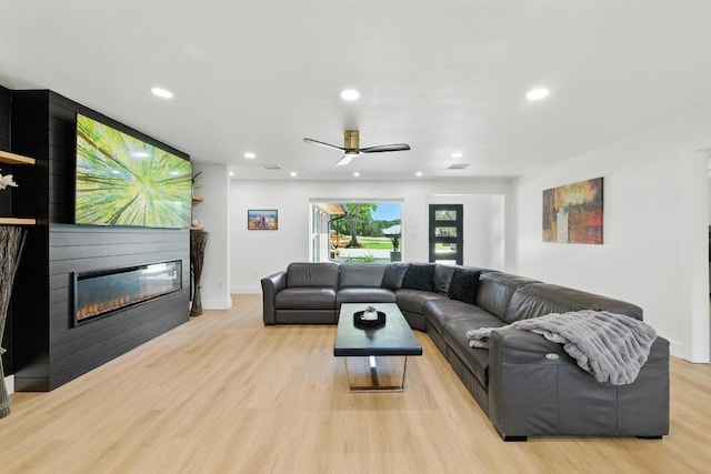 12501 Mixson Dr, Austin, TX 78732 - living room with light wood finished floors, recessed lighting, a large fireplace, and a ceiling fan