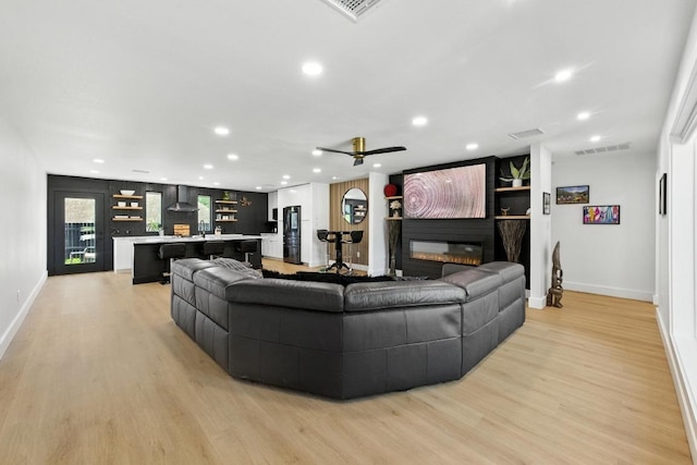 12501 Mixson Dr, Austin, TX 78732 - living area with recessed lighting, light wood-type flooring, a glass covered fireplace, and ceiling fan