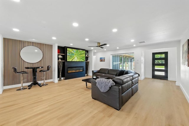 12501 Mixson Dr, Austin, TX 78732 - living area featuring light wood-style floors, a glass covered fireplace, a ceiling fan, and recessed lighting