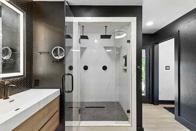 12501 Mixson Dr, Austin, TX 78732 - full bath with a shower stall, wood finished floors, vanity, and decorative backsplash