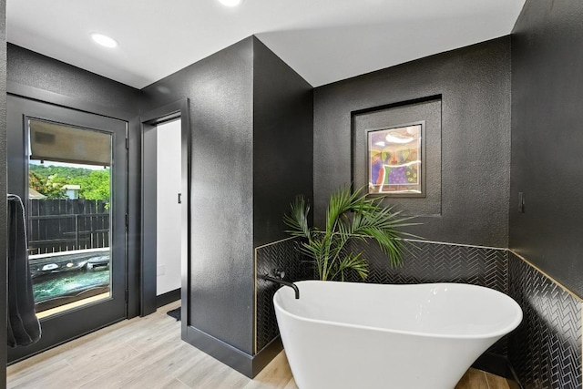 12501 Mixson Dr, Austin, TX 78732 - bathroom featuring a textured wall, wood finished floors, and a freestanding bath