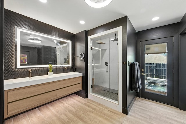 12501 Mixson Dr, Austin, TX 78732 - full bathroom with double vanity, a shower stall, wood finished floors, and recessed lighting