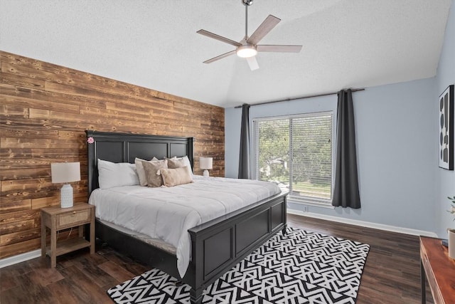501 Battlecreek Ln, Leander, TX 78641 - bedroom with lofted ceiling, wooden walls, dark wood-type flooring, a textured ceiling, and a ceiling fan