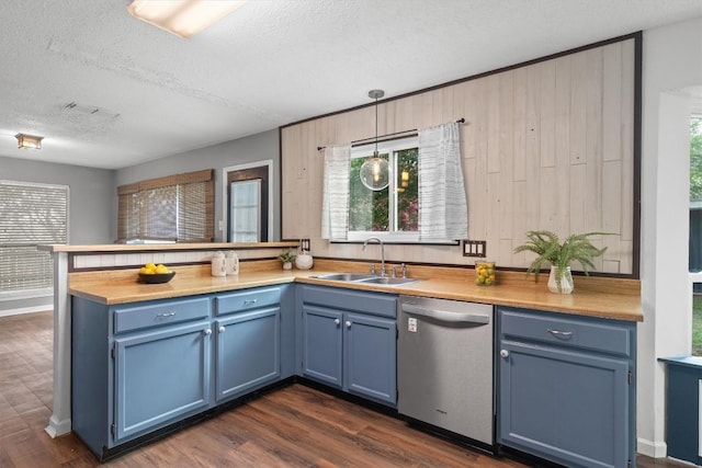501 Battlecreek Ln, Leander, TX 78641 - kitchen featuring stainless steel dishwasher, blue cabinetry, a peninsula, and a textured ceiling