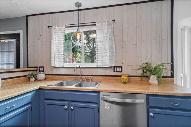 501 Battlecreek Ln, Leander, TX 78641 - kitchen featuring dishwasher, blue cabinets, light countertops, a textured ceiling, and wooden walls