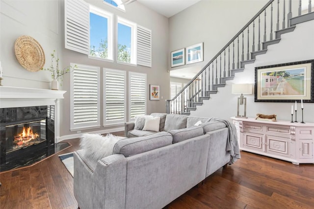 10601 Showboat Cv, Austin, TX 78730 - living room featuring a towering ceiling, dark wood-type flooring, stairs, and a premium fireplace
