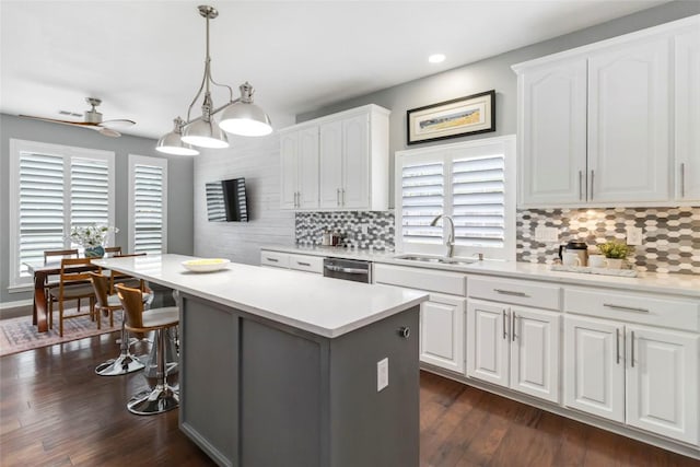 10601 Showboat Cv, Austin, TX 78730 - kitchen with a kitchen island, backsplash, a ceiling fan, a kitchen bar, and white cabinetry