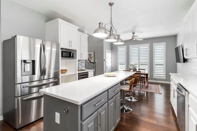 10601 Showboat Cv, Austin, TX 78730 - kitchen featuring stainless steel appliances, gray cabinets, a center island, ceiling fan, and white cabinetry