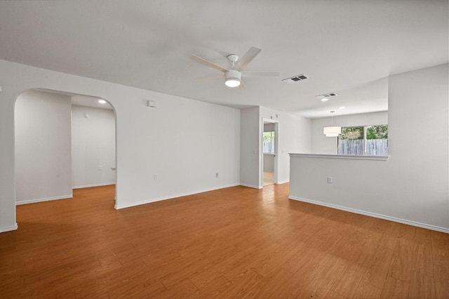 402 Colonial Park Blvd, Austin, TX 78745 - spare room featuring a ceiling fan, arched walkways, and light wood-style flooring