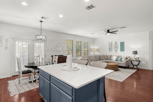 7625 Brecourt Manor Way, Austin, TX 78739 - kitchen with blue cabinets, dark wood finished floors, a ceiling fan, a kitchen island, and recessed lighting