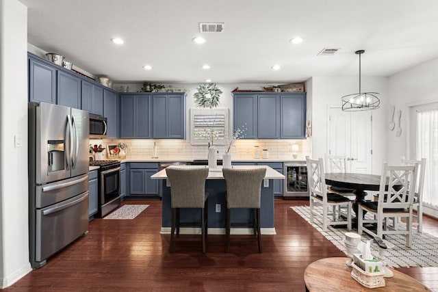 7625 Brecourt Manor Way, Austin, TX 78739 - kitchen with appliances with stainless steel finishes, beverage cooler, light countertops, a kitchen island, and recessed lighting
