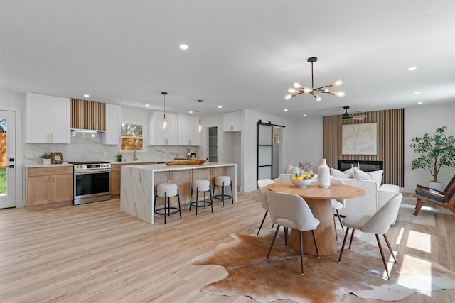 5604 Overbrook Dr, Austin, TX 78723 - dining room featuring a barn door, recessed lighting, light wood-style flooring, and a chandelier