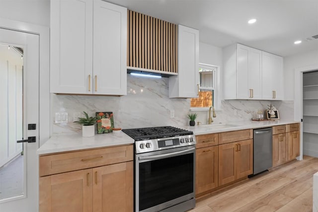 5604 Overbrook Dr, Austin, TX 78723 - kitchen with appliances with stainless steel finishes, light wood-style floors, backsplash, white cabinetry, and recessed lighting