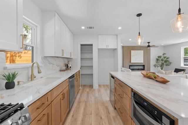5604 Overbrook Dr, Austin, TX 78723 - kitchen with stainless steel appliances, light wood-style floors, recessed lighting, light stone counters, and open floor plan