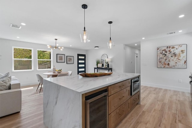 5604 Overbrook Dr, Austin, TX 78723 - kitchen featuring beverage cooler, light wood-style floors, recessed lighting, pendant lighting, and open floor plan