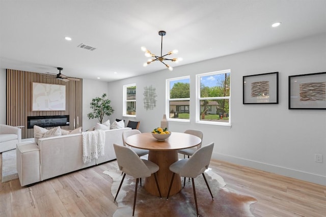 5604 Overbrook Dr, Austin, TX 78723 - dining area featuring light wood finished floors, a chandelier, a glass covered fireplace, and recessed lighting