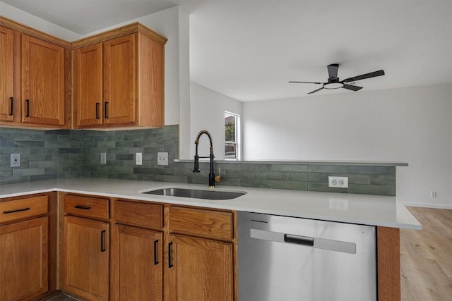 17129 Hamilton Point Cir, Manor, TX 78653 - kitchen with stainless steel dishwasher, light wood-type flooring, decorative backsplash, brown cabinetry, and ceiling fan