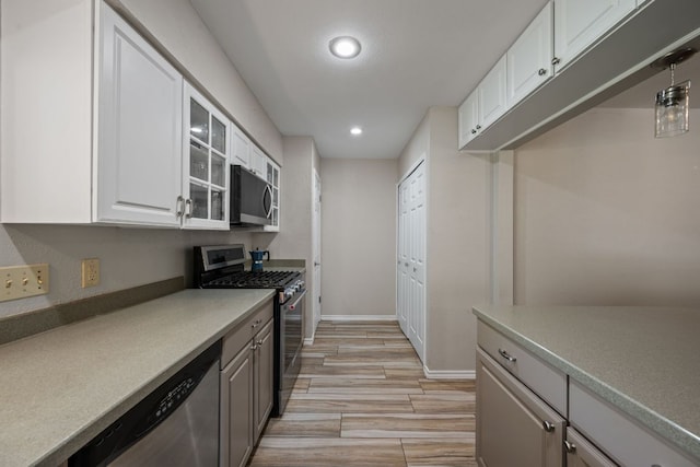 1300 Neans Dr, Austin, TX 78758 - kitchen with stainless steel appliances, recessed lighting, white cabinets, glass insert cabinets, and light wood-style floors