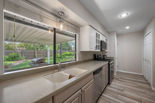 1300 Neans Dr, Austin, TX 78758 - kitchen with appliances with stainless steel finishes, recessed lighting, white cabinets, light countertops, and light wood-style flooring