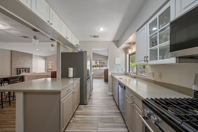 1300 Neans Dr, Austin, TX 78758 - kitchen with appliances with stainless steel finishes, light countertops, glass insert cabinets, open floor plan, and white cabinetry
