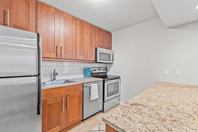 7685 Northcross Dr Unit 720, Austin, TX 78757 - kitchen featuring appliances with stainless steel finishes, decorative backsplash, a textured ceiling, and brown cabinets