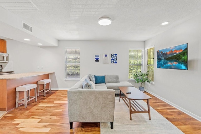 7685 Northcross Dr Unit 720, Austin, TX 78757 - living room featuring plenty of natural light, light wood-type flooring, recessed lighting, and a textured ceiling