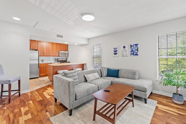 7685 Northcross Dr Unit 720, Austin, TX 78757 - living room featuring light wood-type flooring, a textured ceiling, and recessed lighting
