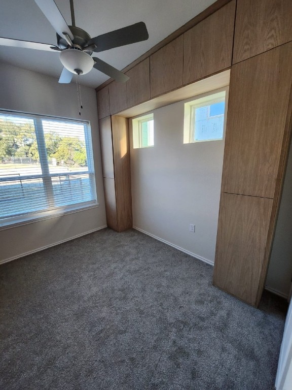 8601 W Gate Blvd Unit 11101, Austin, TX 78745 - unfurnished bedroom with dark colored carpet, multiple windows, and ceiling fan