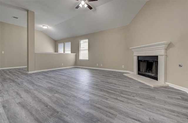 430 Zebra Dr, Kyle, TX 78640 - unfurnished living room with vaulted ceiling, ceiling fan, a fireplace with raised hearth, and wood finished floors