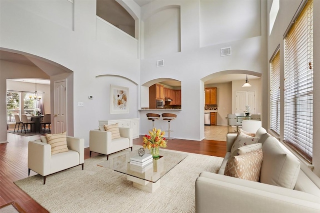 411 S Lynnwood Trl, Cedar Park, TX 78613 - living area with light wood finished floors, a high ceiling, a chandelier, and arched walkways