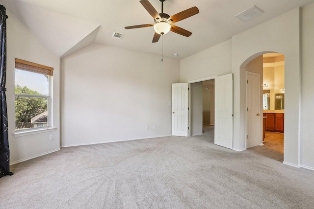 411 S Lynnwood Trl, Cedar Park, TX 78613 - unfurnished bedroom with arched walkways, light colored carpet, ensuite bathroom, ceiling fan, and high vaulted ceiling