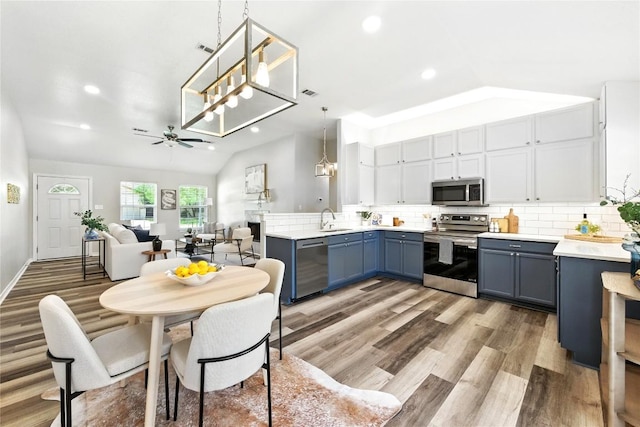 118 W Pauwela Ln, Bastrop, TX 78602 - kitchen featuring appliances with stainless steel finishes, blue cabinets, light wood finished floors, recessed lighting, and ceiling fan