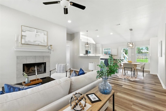 118 W Pauwela Ln, Bastrop, TX 78602 - living room with vaulted ceiling, light wood-style floors, a ceiling fan, a fireplace, and recessed lighting