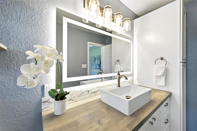 118 W Pauwela Ln, Bastrop, TX 78602 - bathroom featuring vanity, a textured wall, and wood finished floors