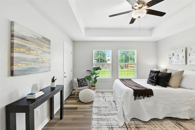 118 W Pauwela Ln, Bastrop, TX 78602 - bedroom with a tray ceiling, wood finished floors, and ceiling fan