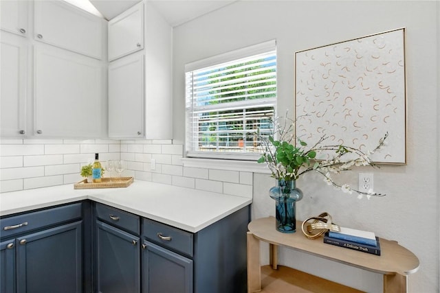 118 W Pauwela Ln, Bastrop, TX 78602 - kitchen with blue cabinets, light countertops, white cabinets, and tasteful backsplash